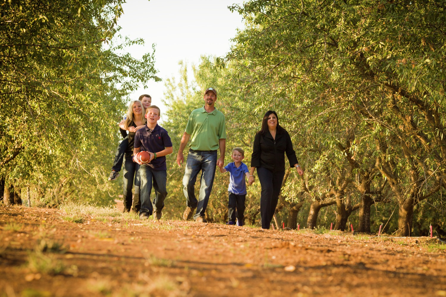 A family walking through an almond orchard.